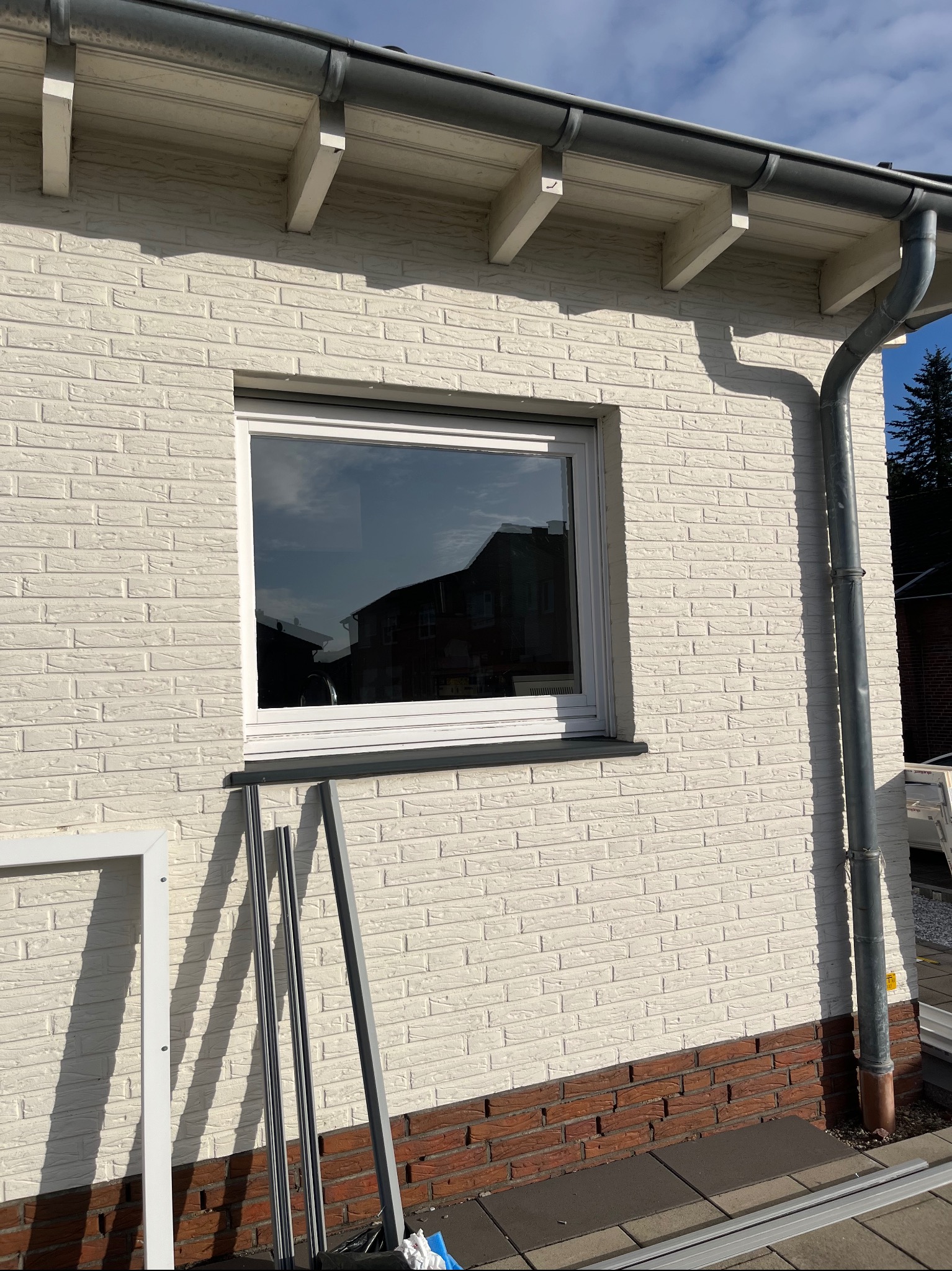 Białe okno z PCV zamontowane w ścianie z białej cegły w Mieczynie, widoczne profile okienne przygotowane do montażu.