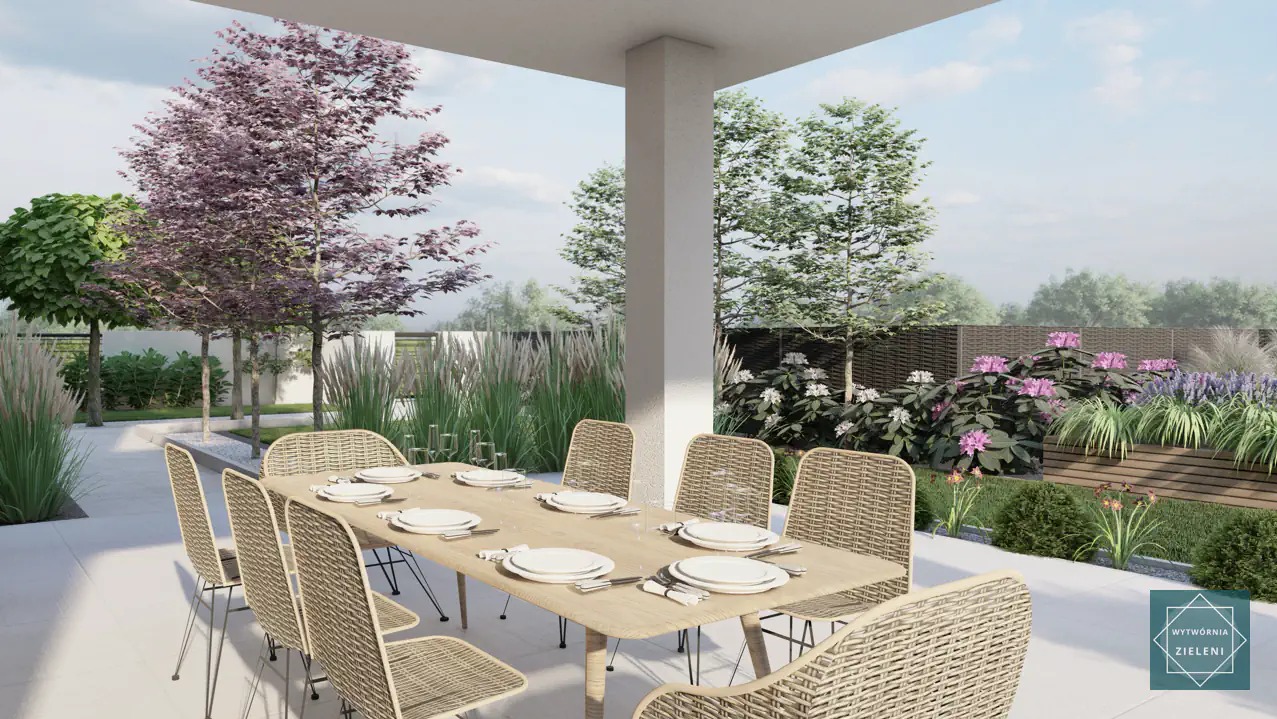 Zadaszony taras z jadalnią na świeżym powietrzu, stół nakryty dla ośmiu osób, rattanowe krzesła, w tle zadbany ogród z kwitnącymi krzewami i drzewami liściastymi.