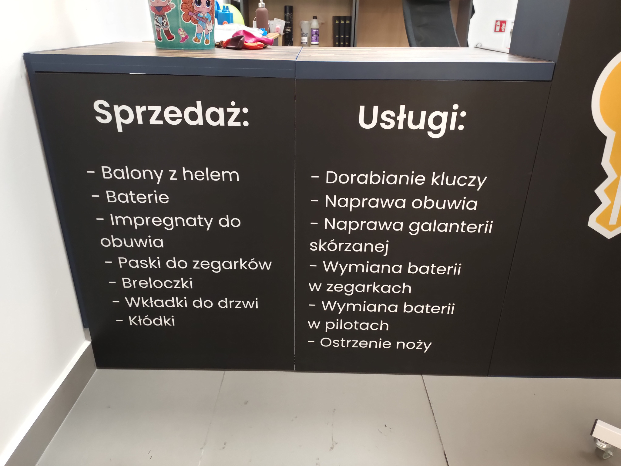 Punkt usługowy z ofertą sprzedaży i usług: dorabianie kluczy, naprawa obuwia, ostrzenie noży, sprzedaż baterii i breloczków.