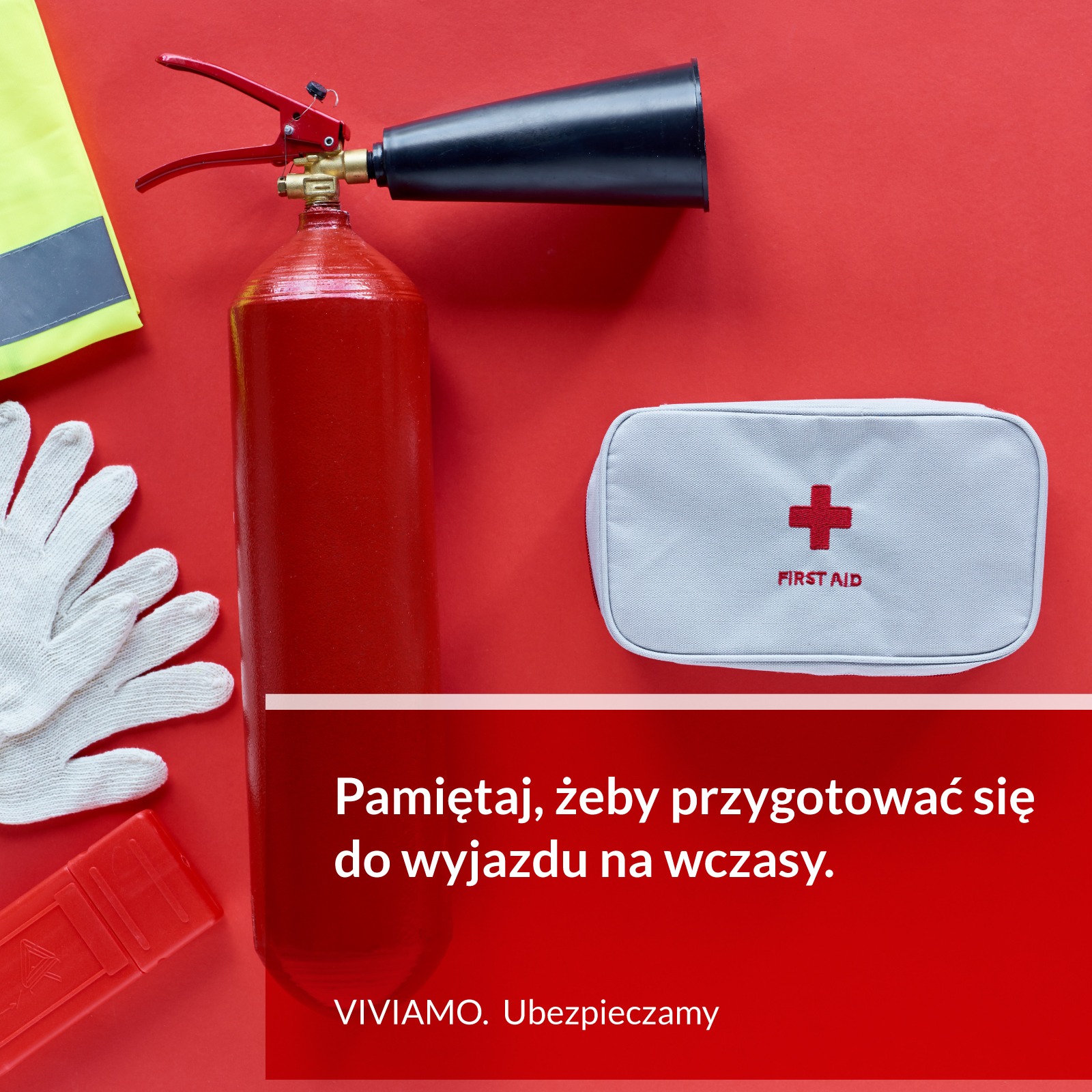 Czerwone tło z gaśnicą, apteczką pierwszej pomocy, kamizelką odblaskową i rękawicami roboczymi, sugerujące przygotowanie do podróży.