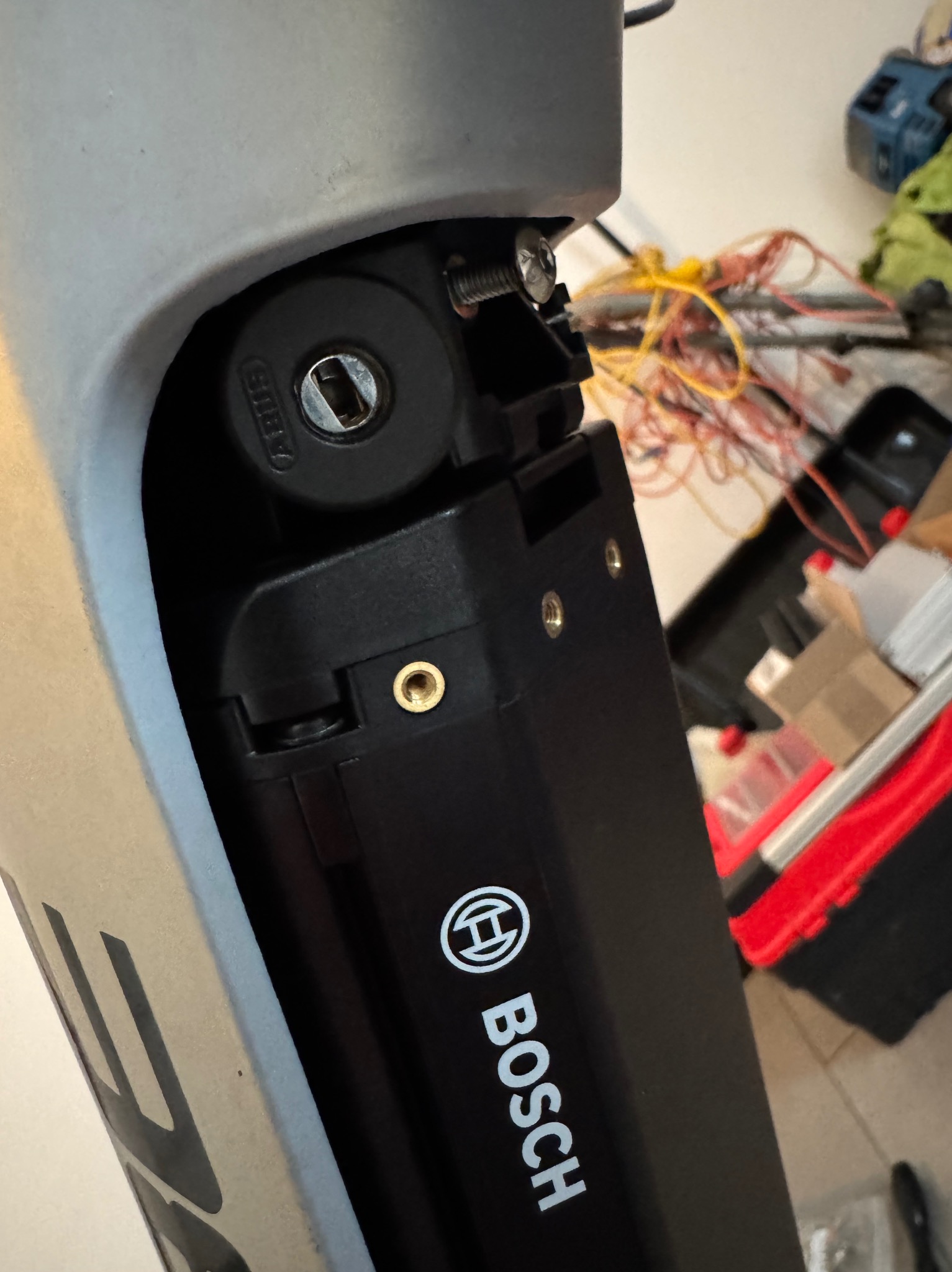 Czarny akumulator Bosch eBike zamontowany w ramie roweru elektrycznego, widoczny zamek zabezpieczający i elementy mocujące.