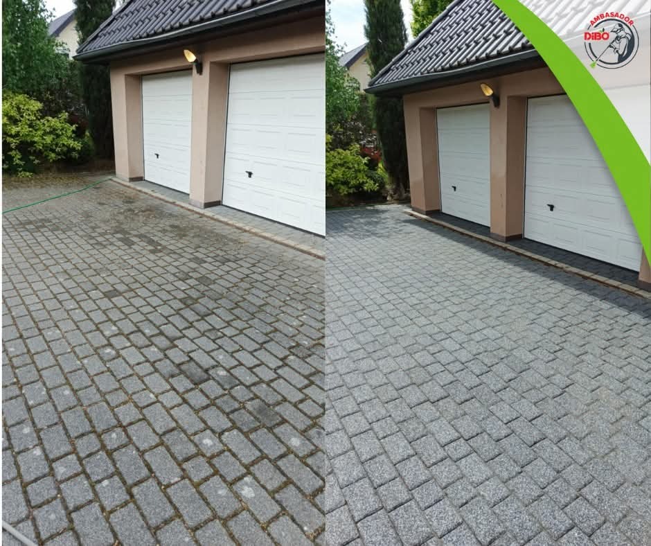 Efekt 'przed i po' czyszczenia kostki brukowej na podjeździe do garażu. Lewa strona zabrudzona, prawa czysta. Widoczny budynek z dwiema bramami garażowymi.