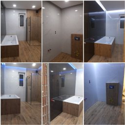 FIRMA OGÓLNOBUDOWLANA DAWID RACZYCKI - Wnętrze łazienki z drewnopodobną podłogą i zabudową wanny, widoczne białe płytki imitujące marmur i czarne, minimalistyczna kabina prysznicowa z czarnymi profilami, oraz fragment ściany w trakcie...