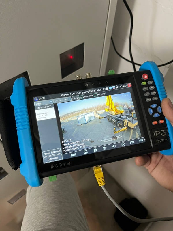 Tester kamer IP z podglądem obrazu z kamery monitoringu na budowie, podłączony kablem Ethernet, widoczny interfejs ONVIF.