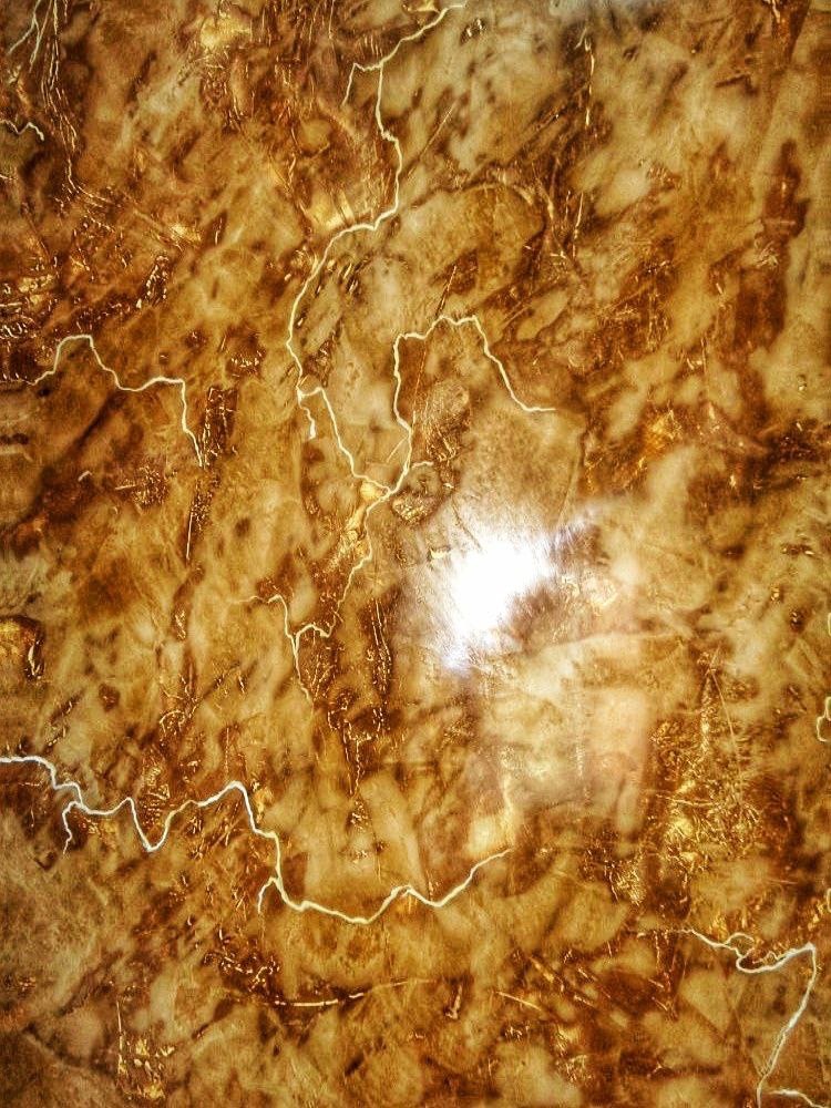 Brązowa ściana z efektem marmuru i delikatnymi, jasnymi żyłkami, wykończona z połyskiem