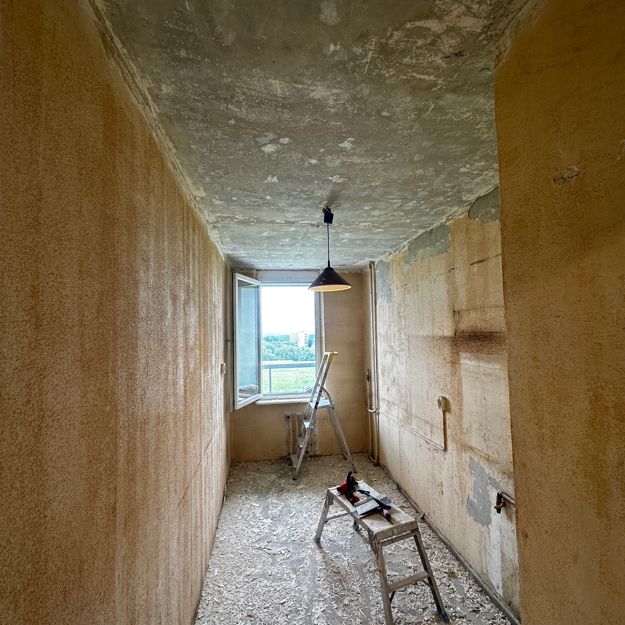 Pokój w trakcie przygotowań do remontu w Tychach. Widoczne ślady po usuniętej tapecie, drabina i narzędzia. Przygotowanie do gładzi.