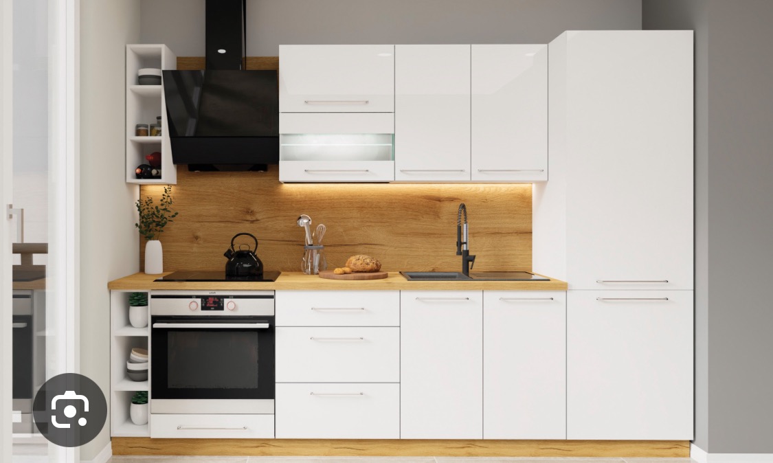 Biała kuchnia z drewnianym blatem i oświetleniem LED pod szafkami wiszącymi. Nowoczesny design z czarnym okapem i elementami dekoracyjnymi.