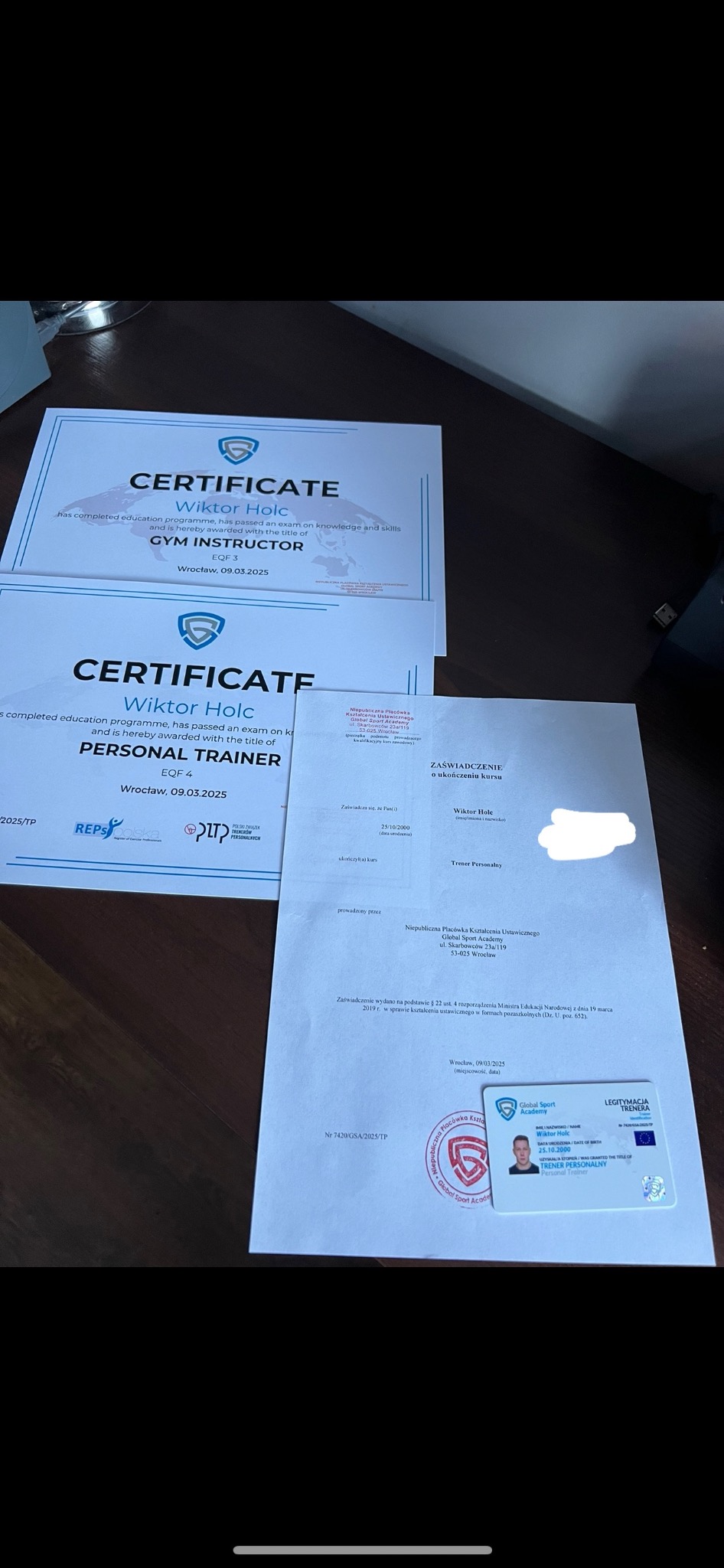 Dokumenty trenera personalnego: certyfikaty ukończenia kursów, zaświadczenie i legitymacja trenera Global Sport Academy Wiktora Holca.