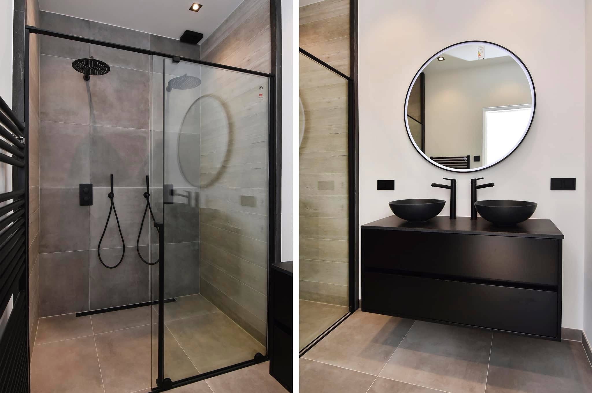 Nowoczesna łazienka z kabiną prysznicową typu walk-in z czarnymi ramami, deszczownicą i baterią podtynkową, oraz umywalką nablatową w czarnej szafce z okrągłym lustrem.
