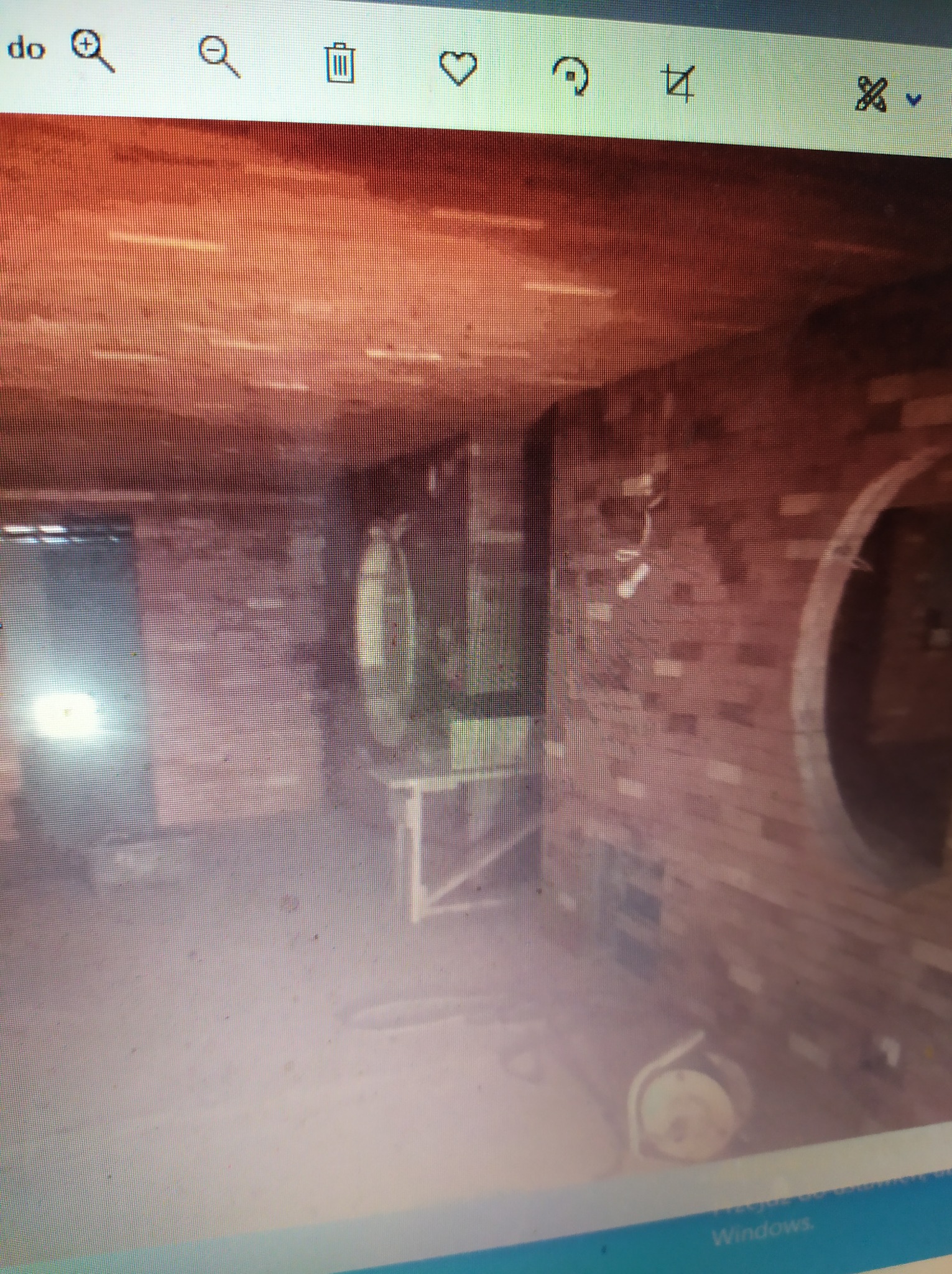 Surowa cegła w trakcie prac wykończeniowych, widoczne niedokończone okrągłe wnęki, przewody elektryczne i narzędzia budowlane w pomieszczeniu.