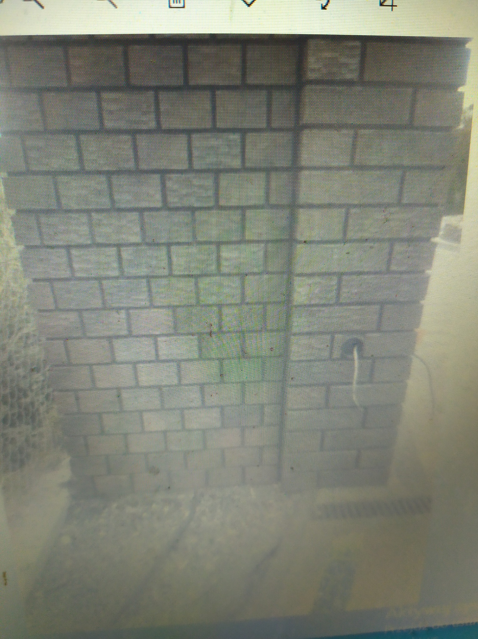 Szara ściana z cegły z wystającym gniazdkiem i kablem, widoczne ślady po fugowaniu.