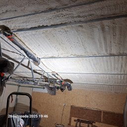 GAWEŁCZYK IZOLACJE NATRYSKOWE - Szczegółowe ujęcie izolacji pianką PUR poddasza z widocznymi elementami konstrukcyjnymi i osprzętem, ukazujące strukturę i dokładność wykonania.