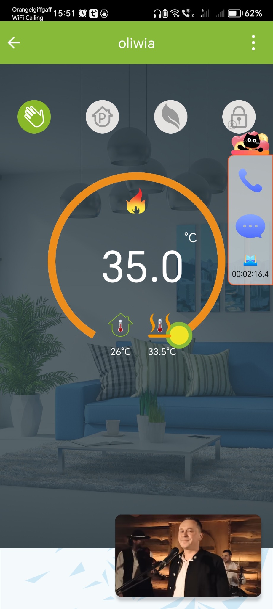 Zrzut ekranu aplikacji mobilnej do sterowania temperaturą w domu, wyświetlający aktualną temperaturę 35 stopni Celsjusza, z wizualizacją wnętrza salonu w tle i wideo w dolnej części ekranu.