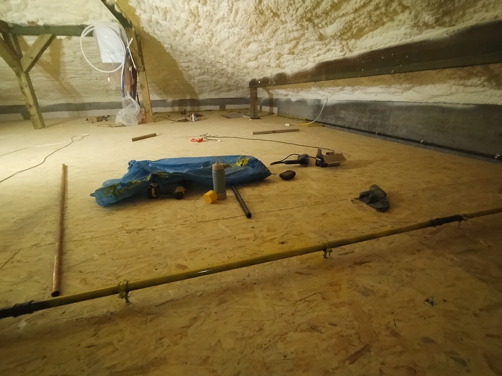 Instalacja gazowa w trakcie montażu na poddaszu w Gdyni, widoczne rury gazowe, izolacja piankowa na suficie, narzędzia i materiały budowlane.