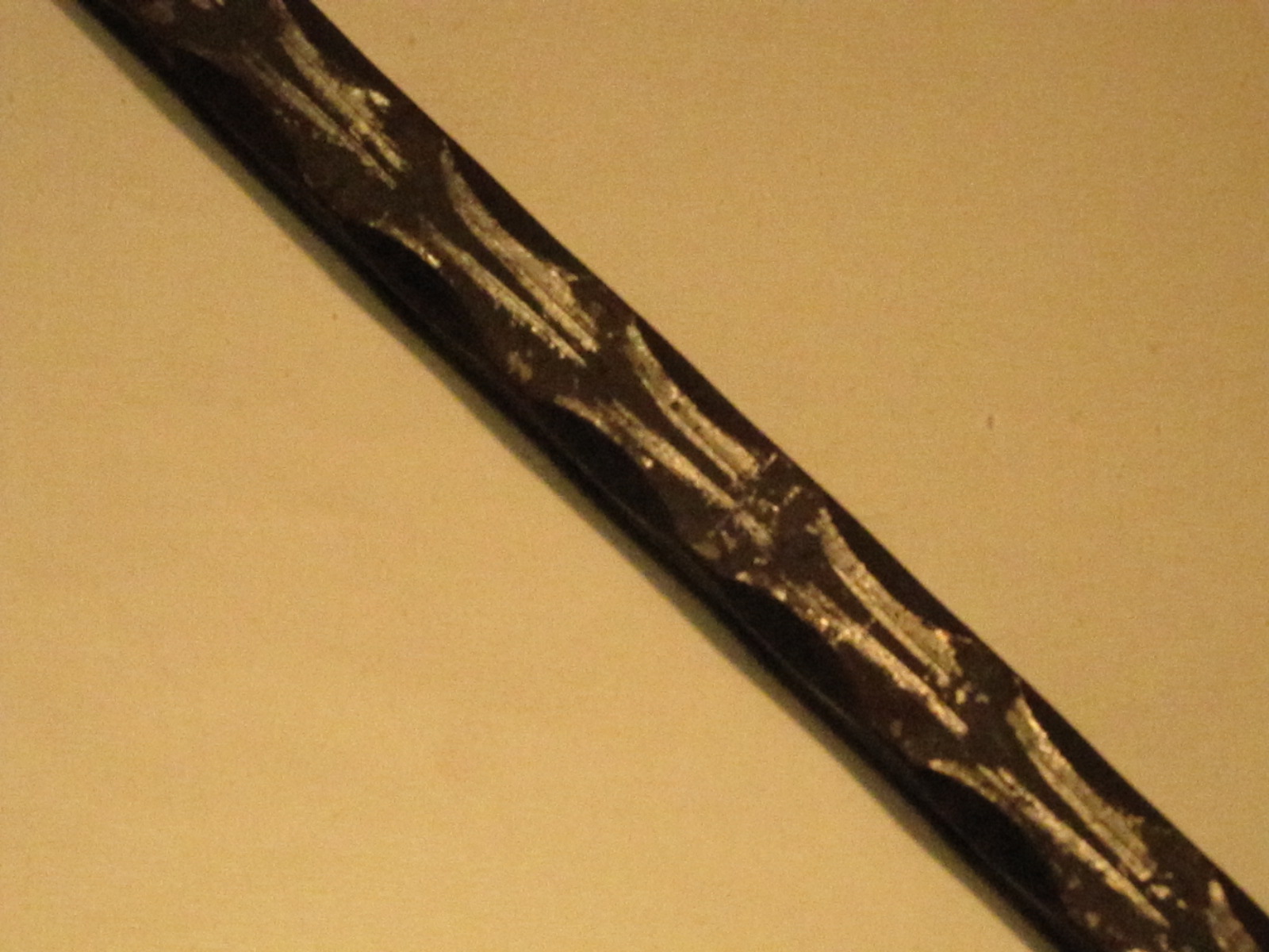 Detal ozdobnego walcowania stali, prawdopodobnie element balustrady wykonanej w Świątnikach Górnych, widoczny pod kątem na jasnym tle.