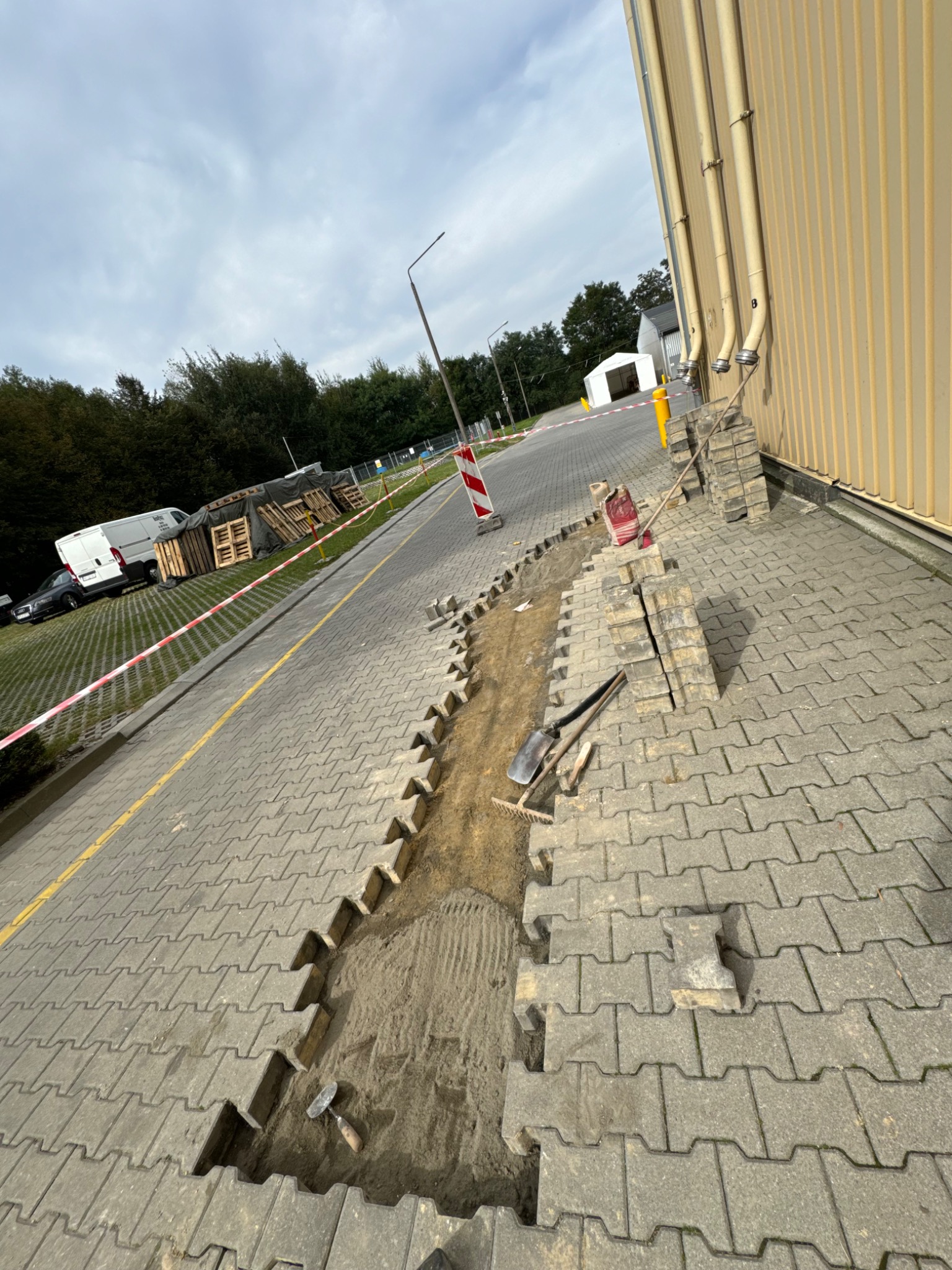 Wyrównywanie kostki na terenie fabryki paszy dla zwierząt.