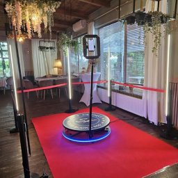 Paweł Łukasik - Kompletna fotobudka 360 na czerwonym dywanie w eleganckim wnętrzu z dekoracjami kwiatowymi. Gotowa do użycia na imprezie.