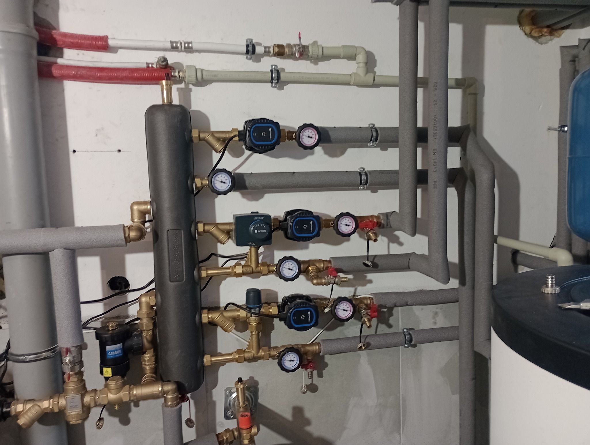 Rozbudowana instalacja grzewcza z rozdzielaczem, pompami obiegowymi i manometrami, rury zaizolowane termicznie, Łańcut.