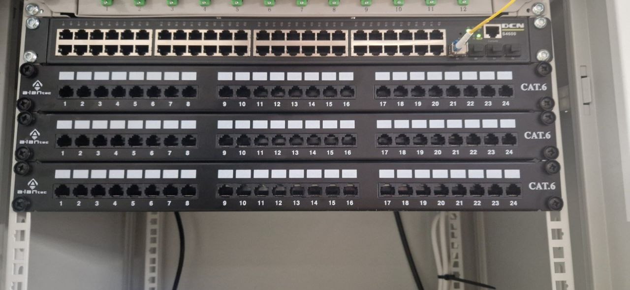 Panel krosowniczy CAT.6 z portami oznaczonymi numerami, zainstalowany we Wrocławiu, z podłączonym kablem światłowodowym w górnym rzędzie.