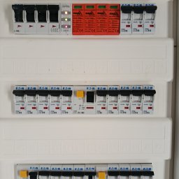 Marcin - Rozdzielnica elektryczna z bezpiecznikami Eaton i Bemko, widoczne oznaczenia i numery. Instalacja wewnątrz budynku, widok z bliska, równomierne oświetlenie.