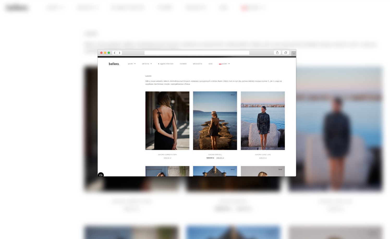 Ekran komputera wyświetla stronę internetową sklepu odzieżowego z kolekcją sukienek, widok zza ramki przeglądarki.