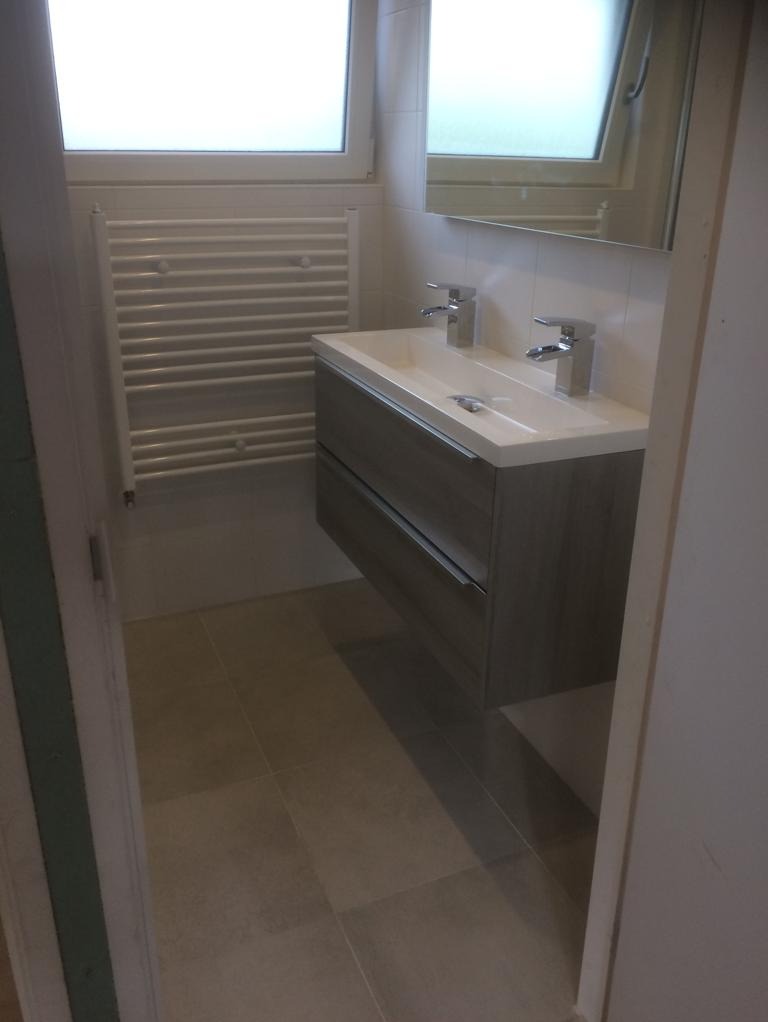 Nowoczesna umywalka z szufladami w odcieniach szarości, podwójna bateria, grzejnik drabinkowy w tle, Koszarówka.