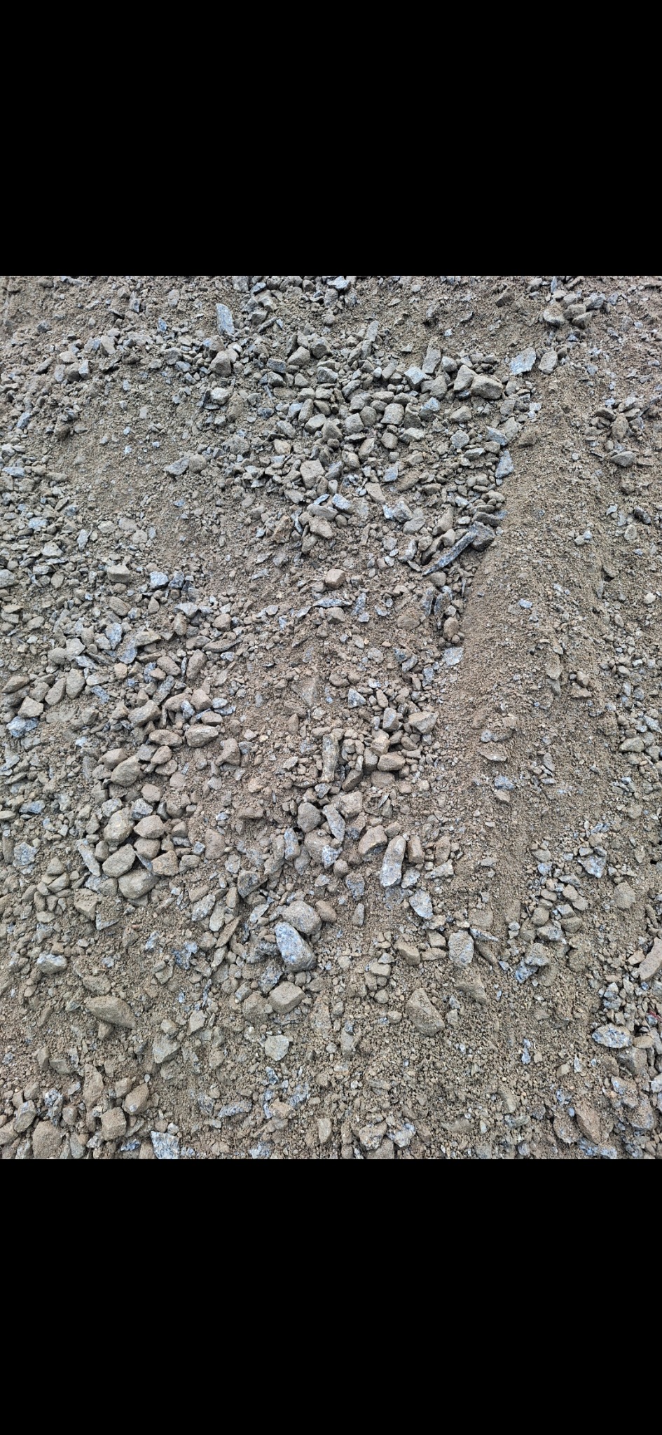 Drobny żwir i piasek w zbliżeniu, widoczna wyraźna granica między frakcjami, szaro-brązowa kolorystyka.