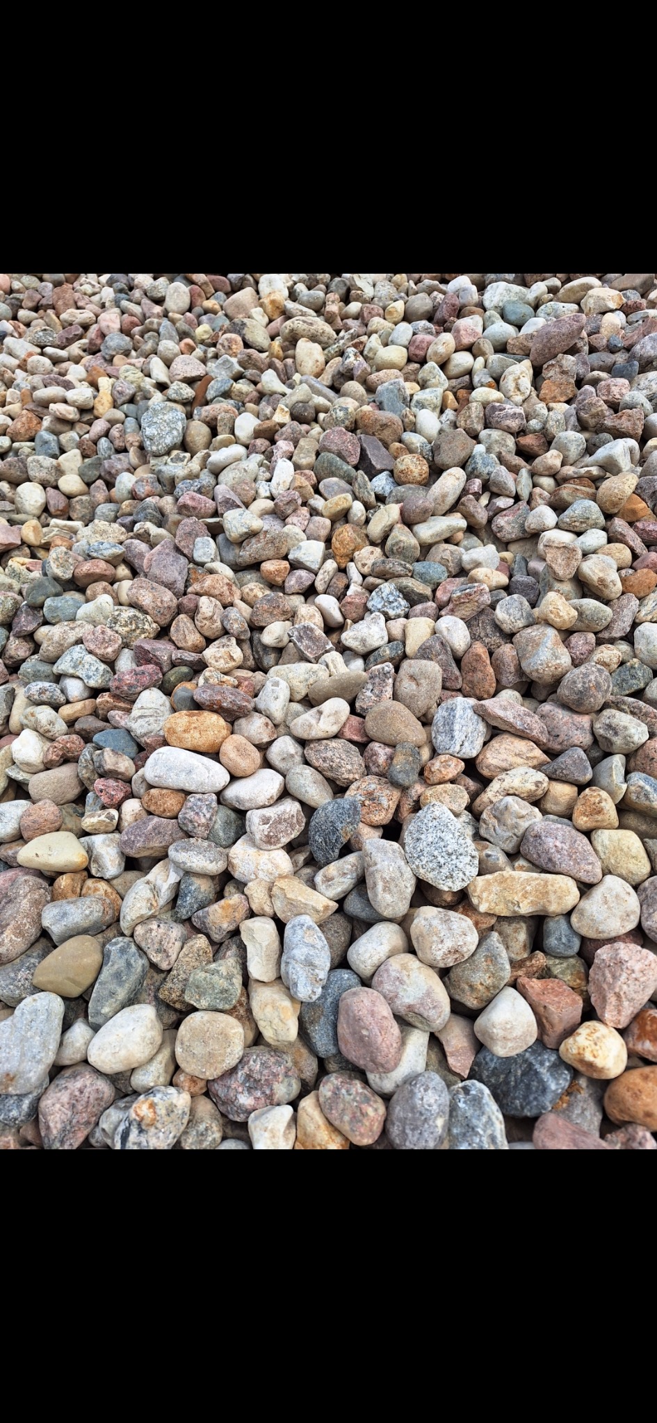 Góra różnokolorowego, drobnego kamienia ozdobnego, widok z góry, zróżnicowana faktura i odcienie brązu, szarości i beżu.