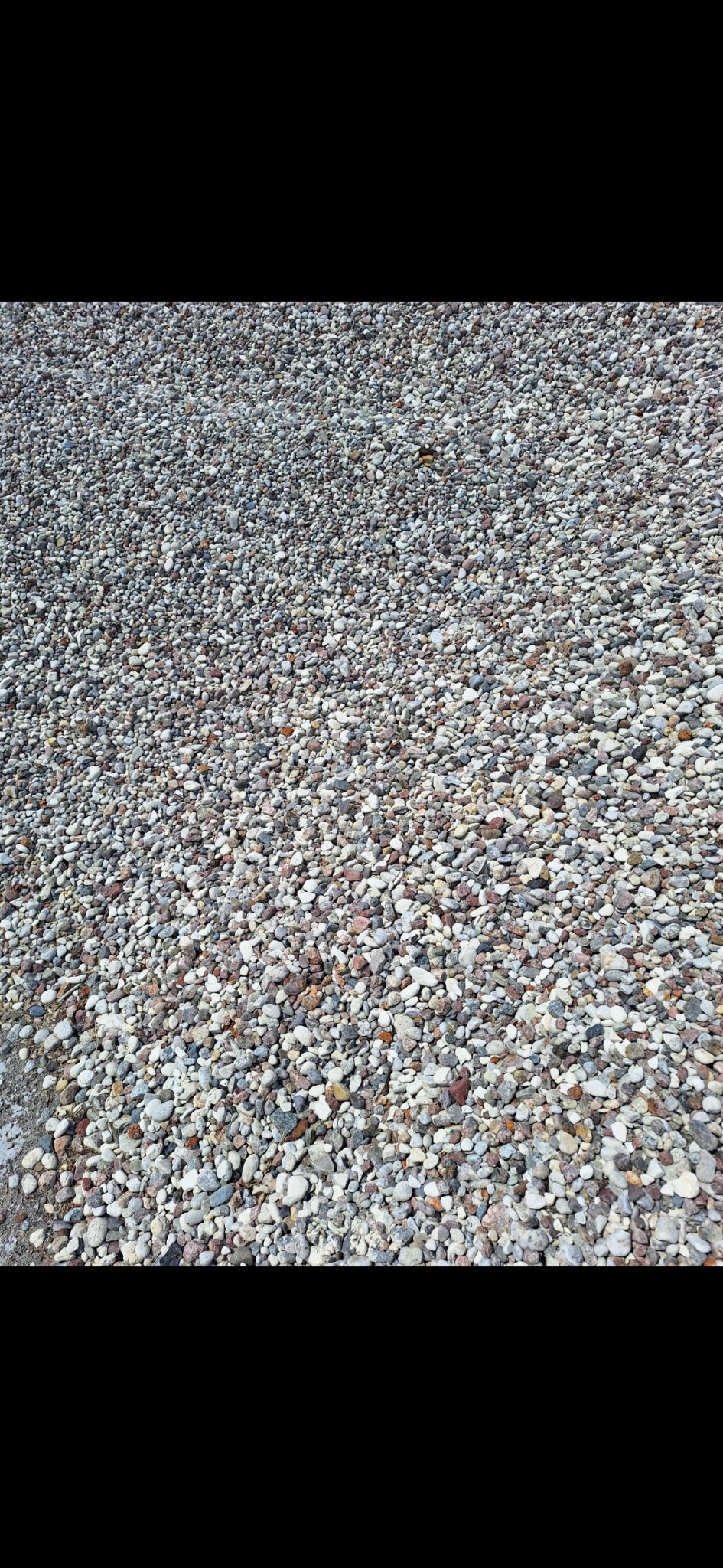 Drobne, wielobarwne kamienie tworzące równą powierzchnię, widoczne z bliska.