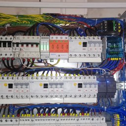 Vasyl Stetsiuk - Rozdzielnica elektryczna z licznymi przewodami, bezpiecznikami i modułami, widoczne marki Eaton i Simtec, okablowanie w kolorach żółtym, niebieskim, brązowym.