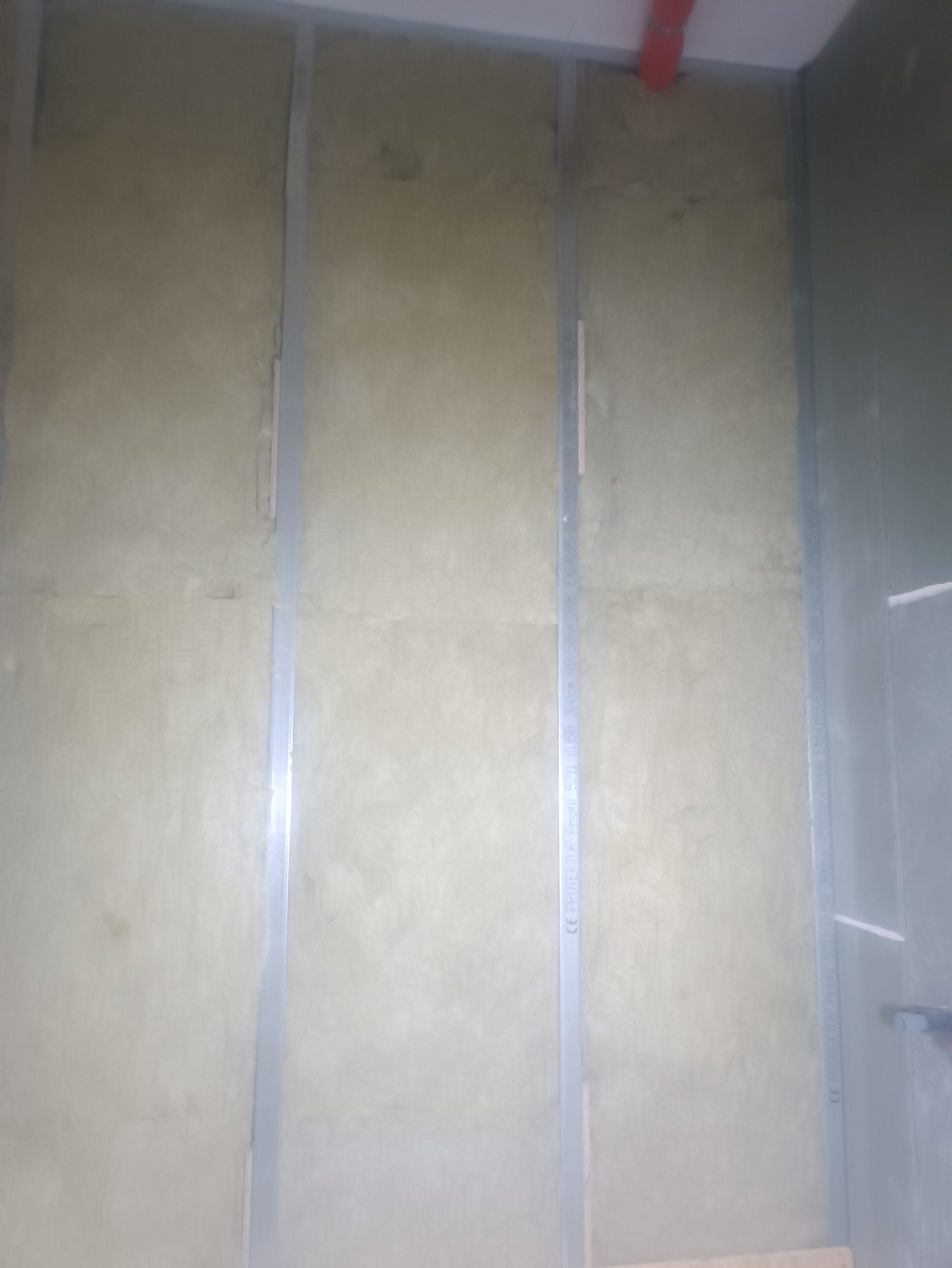 Ściana z izolacją z wełny mineralnej i metalowymi profilami w Ludwinie, przygotowana pod montaż płyt karton-gips.