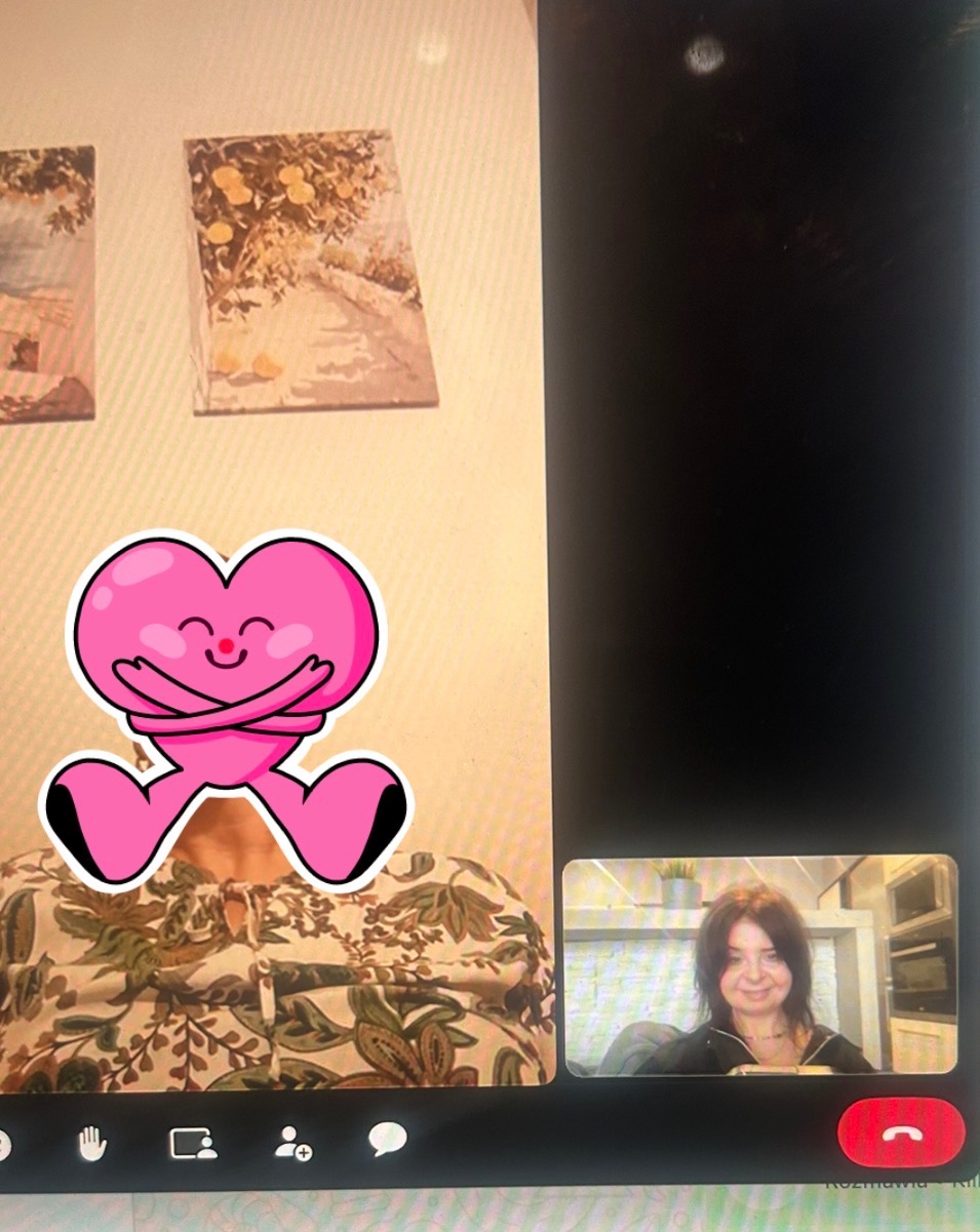 Rozmowa wideo z psychologiem/terapeutą, twarz zasłonięta naklejką. Widoczny fragment pokoju z obrazami na ścianie i okno rozmowy z uśmiechniętą kobietą.