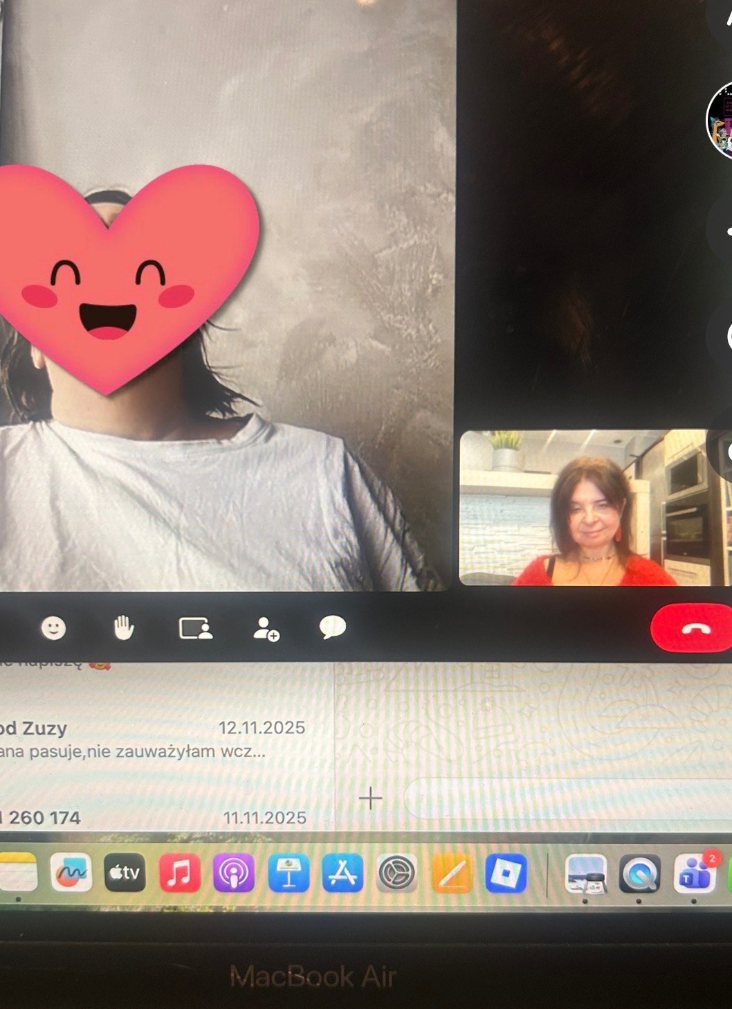 Ekran laptopa z widokiem rozmowy wideo. Po lewej osoba z zakrytą twarzą emotikoną serca, po prawej kobieta w czerwonej bluzce. Widoczny interfejs komunikatora i pasek dock.