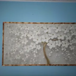 Tapeta z motywem kwitnącego drzewa z białymi kwiatami i złotym pniem, umieszczona na błękitnej ścianie.