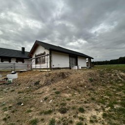 MODERN THERMO BUILDINGS SPÓŁKA Z OGRANICZONĄ ODPOWIEDZIALNOŚCIĄ - Dwa domy w trakcie ocieplania elewacji, styropian i rusztowania widoczne, pochmurne niebo w tle.