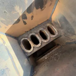 Wewnętrzny widok spawanej konstrukcji z czterema owalnymi otworami, widoczne spoiny i ślady obróbki.