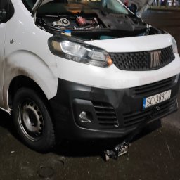 Pomoc drogowa Mobilny serwis HOL-MOBIL - Biały samochód dostawczy marki Fiat z otwartą maską, pod którą widoczne są narzędzia i części; na ziemi leżą zdemontowane elementy, a pod przednim zderzakiem znajduje się podnośnik.