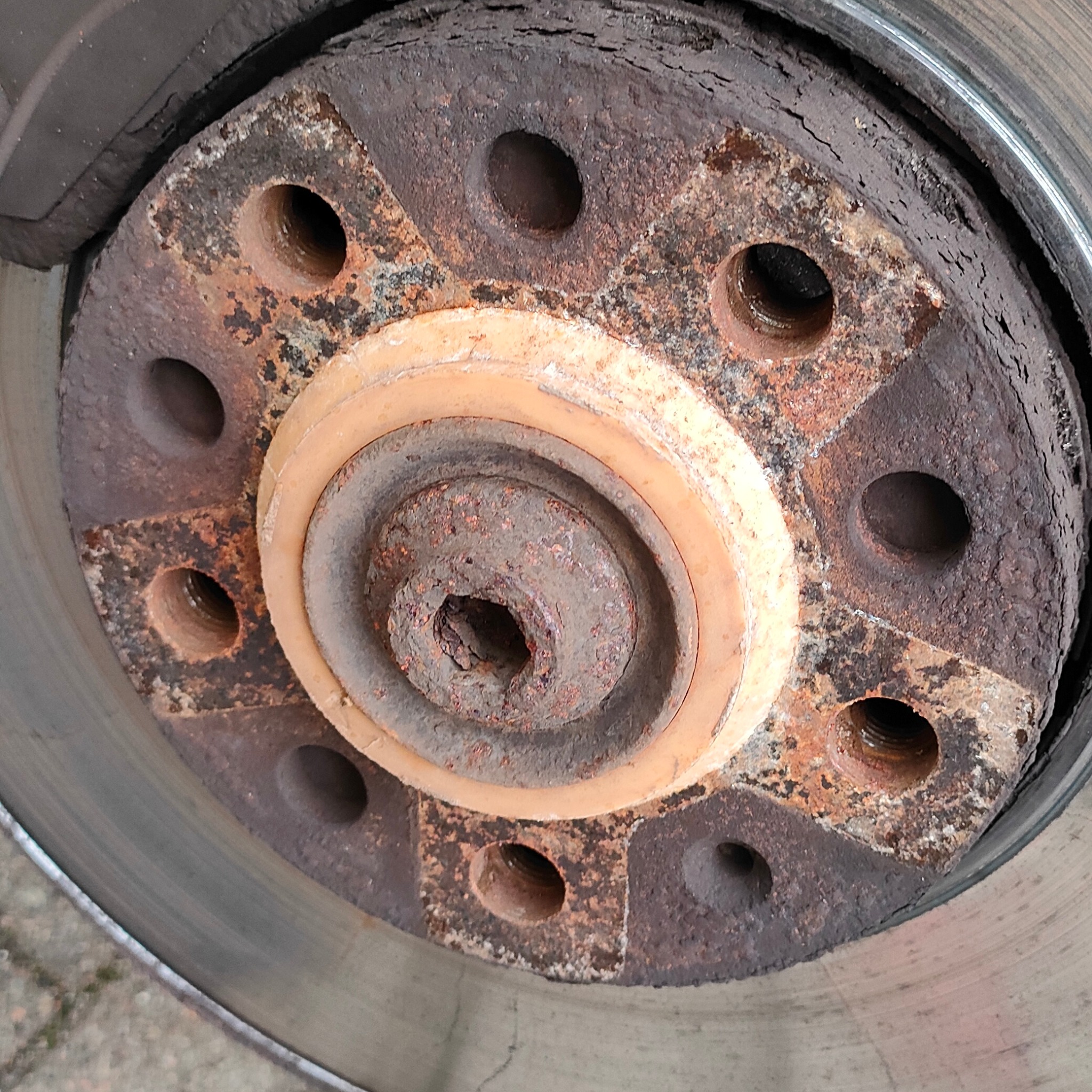 Zużyta, skorodowana tarcza hamulcowa z widocznymi śladami rdzy i zużycia, z bliska.