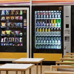BATEX WOJCIECH KMERA - Automaty sprzedające napoje, słodycze i kawę w pomieszczeniu z miejscami do siedzenia.