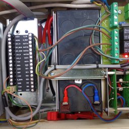 Dariusz Miodek MaxSerwis - Rozdzielnica elektryczna z przewodami, złączkami i elementami elektronicznymi. Widoczne kable w różnych kolorach, płytki drukowane i zasilacz impulsowy.