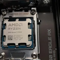 Zamontowany procesor AMD Ryzen 7 9700X na płycie głównej B650 Eagle AX z gniazdem Socket AM5. Widoczne detale chipu i slotów pamięci DDR5. Precyzyjny montaż komponentów PC.