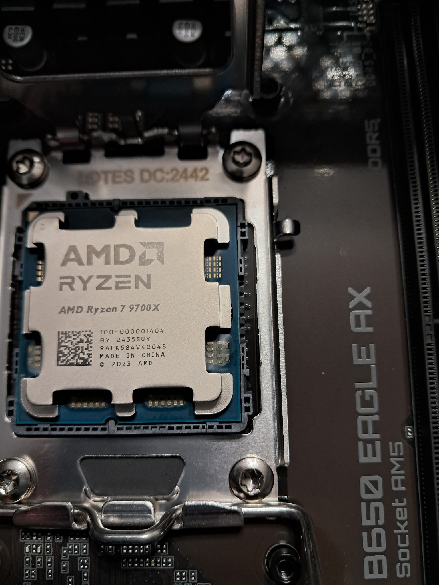 Zamontowany procesor AMD Ryzen 7 9700X na płycie głównej B650 Eagle AX z gniazdem Socket AM5. Widoczne detale chipu i slotów pamięci DDR5. Precyzyjny montaż komponentów PC.