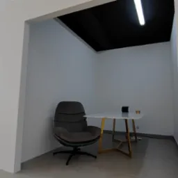 Wnętrze biura po remoncie: świeżo pomalowane, jasne ściany, czarny sufit, designerski fotel i stolik na złotych nogach, widoczny odkurzacz w tle.