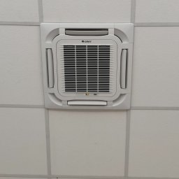 KLIMAPROWENT ALIK DOROV - Klimatyzator kasetonowy marki Gree zamontowany w suficie podwieszanym, widoczny wyświetlacz temperatury.