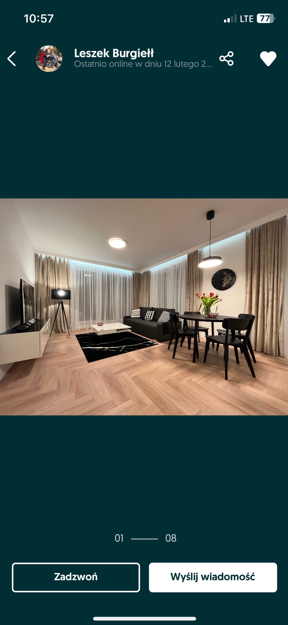 Salon z parkietem ułożonym w jodełkę, czarnym dywanem imitującym marmur, szarym narożnikiem i czarnym stołem z krzesłami.