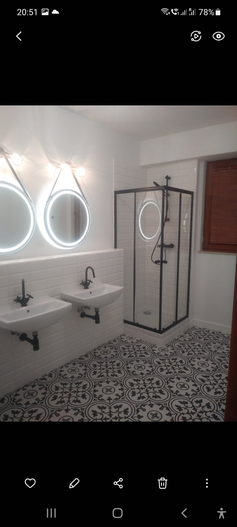 Wykończona łazienka w stylu retro z dwoma umywalkami na tle białych płytek metra, czarną armaturą i kabiną prysznicową z czarnymi profilami oraz wzorzystą podłogą.