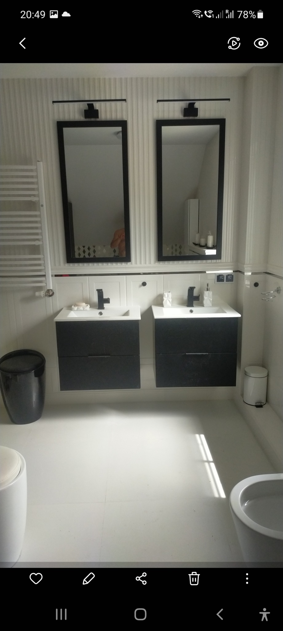 Jasna łazienka z dwiema umywalkami nablatowymi z czarnymi szafkami, dużymi lustrami w czarnych ramach i białymi płytkami na ścianach.