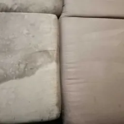 Porównanie dwóch poduszek sofy: po lewej stronie widoczna wyraźna plama i zabrudzenia, po prawej poduszka po czyszczeniu, jednolity kolor i brak plam.