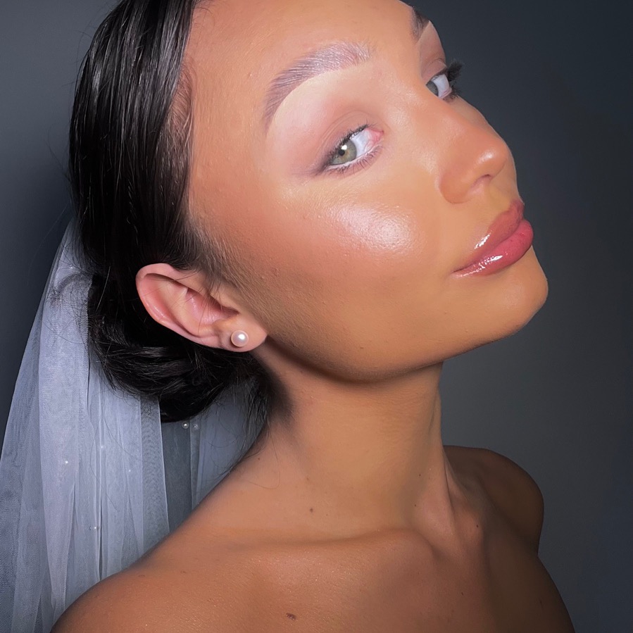 Profil kobiety z promienną cerą, błyszczącymi ustami i delikatnym welonem, ukazujący efekt końcowy stylizacji ślubnej