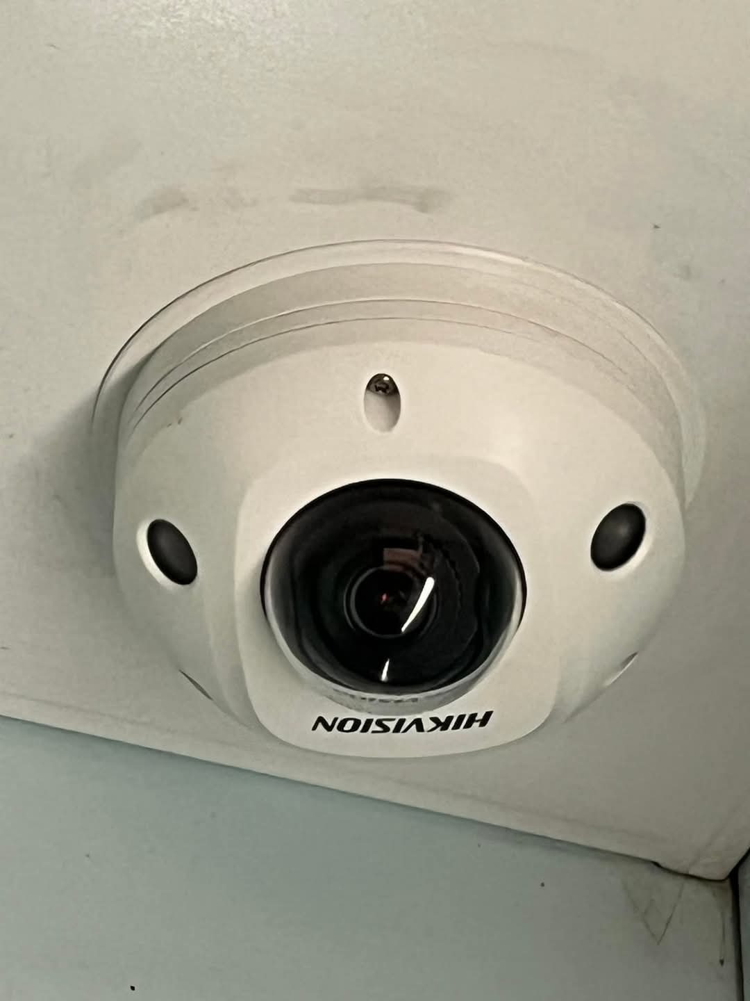 Kamera kopułkowa Hikvision zamontowana na suficie z widocznymi zabrudzeniami.